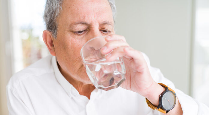 An old man drinking water