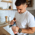 Young man making protein shake before training