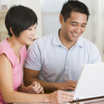 Couple in dining room with laptop smiling
