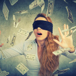 Blindfolded young entrepreneur  businesswoman trying to catch do