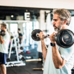 Mature man pushing weights in a health club.