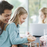 Father watching daughter count coins