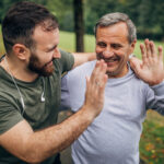 Man and son exercising in park together