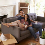 Couple On Sofa Taking A Break From Unpacking On Moving Day