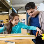 Hispanic girl learns to measure in woodworking day camp