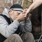 Homeless man taking a woman’s hand