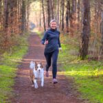 Healthy fit woman running with her dog