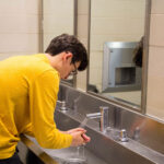 Teen Washing hands in Public Bathroom