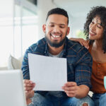 Couple sitting on couch looking at finances