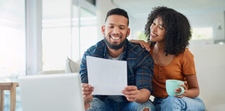 Couple sitting on couch looking at finances