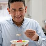 Man eating fruit from a bowl