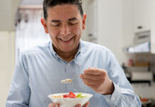 Man eating fruit from a bowl