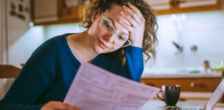 Woman in glasses revieiwing insurance info sheet
