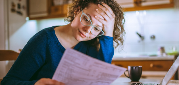 Woman in glasses revieiwing insurance info sheet