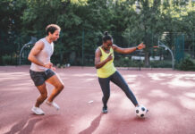 young sportsman and woman playing soccer on hardcourt