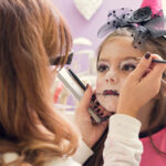 Mother applying make-up on daughter for Halloween