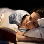 Woman reading book in bed