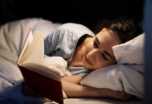 Femme lisant un livre dans un lit.
