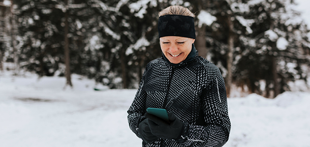 Happy woman outside looking at her phone.