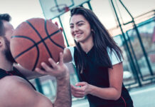 Jeune couple jouant au basket-ball.