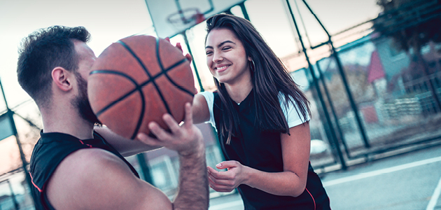 Jeune couple jouant au basket-ball.