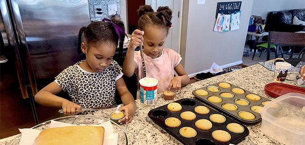 Two girls baking cupcakes in a kitchen