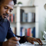 Man writing at desk.