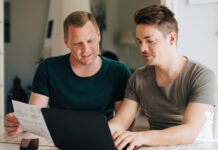 Deux hommes assis devant un ordinateur en train de planifier