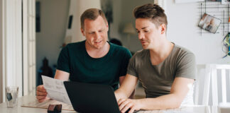Two men sitting at a computer planning together