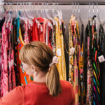 Woman looking through dresses on clothing rack