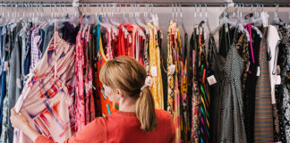 Woman looking through dresses on clothing rack