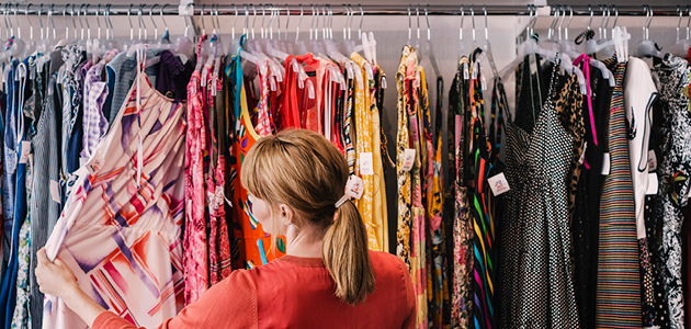 Woman looking through dresses on clothing rack