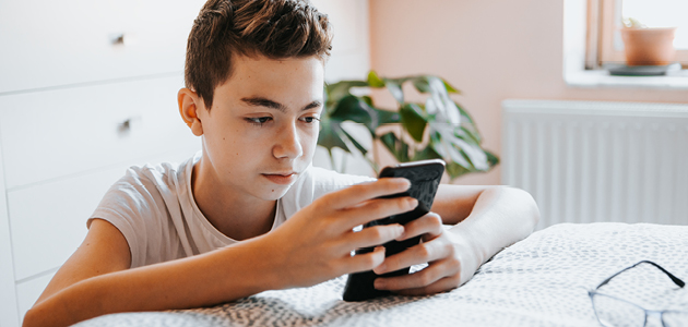 Pré-adolescent regardant son téléphone portable