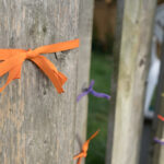 Orange ribbons tied to a fence