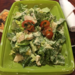 Caeser salad, no croutons, on a takeout plate