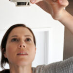 Woman changing smoke detector