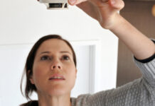 Woman changing smoke detector