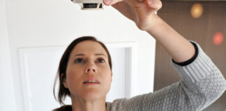 Woman changing smoke detector