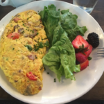 Omelet with side salad of lettuce and berries on a plate