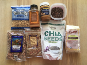 packaged goods, including peanut butter, chia seeds, shredded coconut, almonds, sunflower seeds, and salted peanuts. 