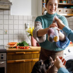 Man passing woman a bag of produce in the kitchen