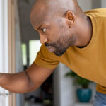 Man checking home thermostat