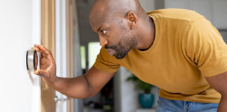 Man checking home thermostat