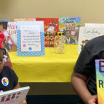 Young girls displaying books that celebrate Black History Month