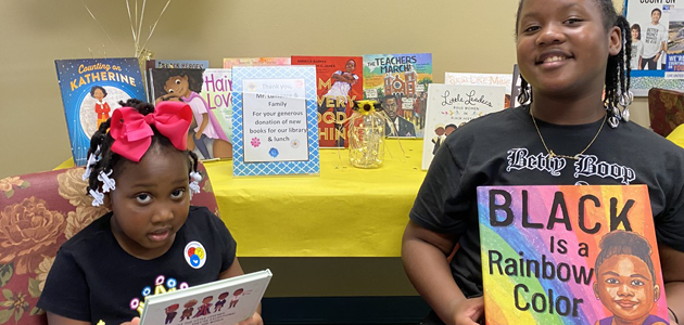 Jeunes filles exposant des livres célébrant le Mois de l'histoire des Noirs
