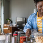 Woman preparing to cook with canned food ingredients