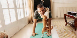 Man doing yoga with his dog