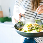 Woman holding a large bowl of pasta